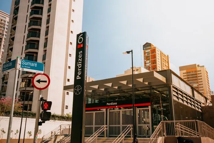 Entrada da estação Perdizes, com o totem de sinalização e os edifícios ao redor
