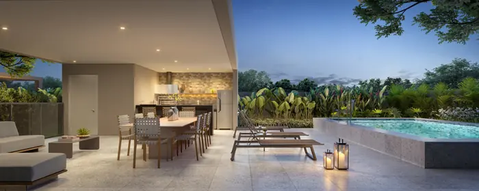 Varanda coberta com mesa de jantar, espreguiçadeiras e lanternas acesas ao lado de uma piscina, ao anoitecer