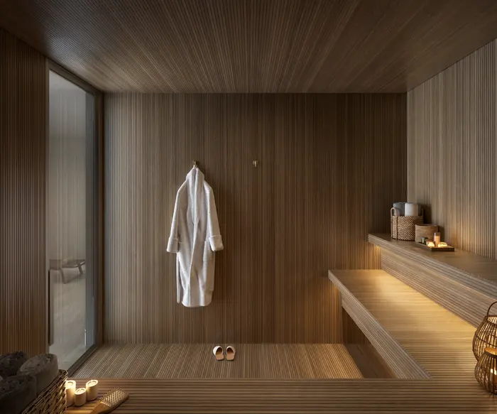 Sauna revestida de madeira ripada, com bancos, roupão pendurado e velas acesas
